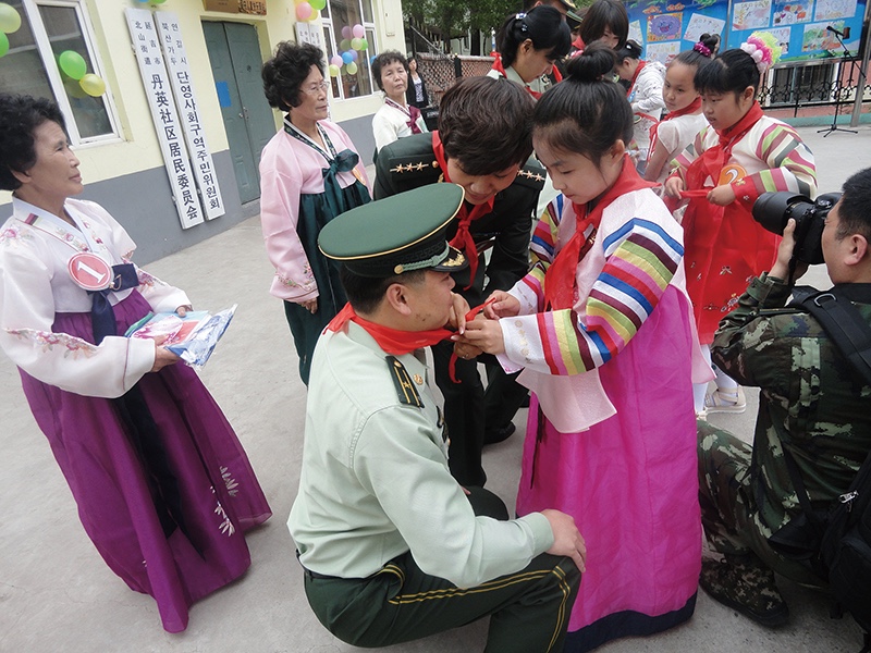 朝鲜族留守儿童为汉族军爸爸系红领巾.JPG