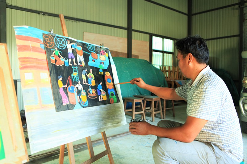喊沙寨的农民画家吞也正在作画，画中的描绘的是傣族群众的酿酒过程.JPG