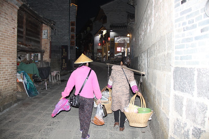 3、在腾冲市和顺古镇卖松花糕的佤族妇女姜聪留（左一）傍晚收工回家.jpg