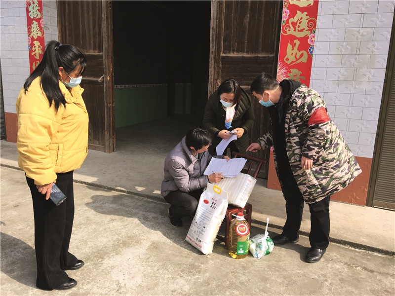 10. 村支部书记胡华山（右）、村主任姜晓玲（左）为贫困户送大米和食油.jpg