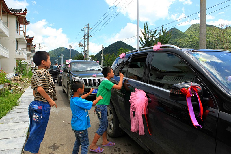 村里的孩子兴高采地扒在车窗上看新娘子。.jpg