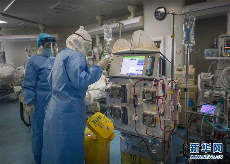 9. 3月19日，在武汉市肺科医院重症监护室，浙江医疗队队员丁杨（左）与同事为患者做ECMO（人工膜肺）治疗。新华社记者 肖艺九 摄.jpg